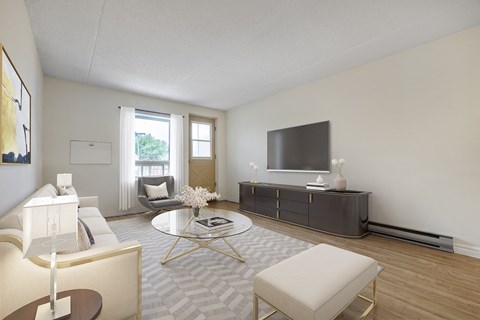 A living room with a white sofa, a coffee table, and a television.