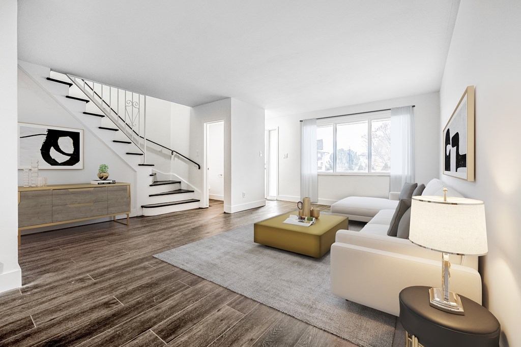 A modern living room with a staircase and a couch.