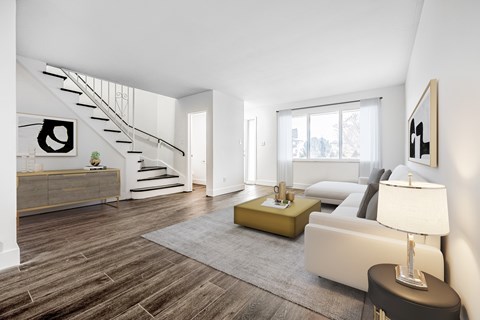A modern living room with a staircase and a couch.