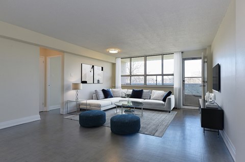 A living room with a white couch and blue ottomans.