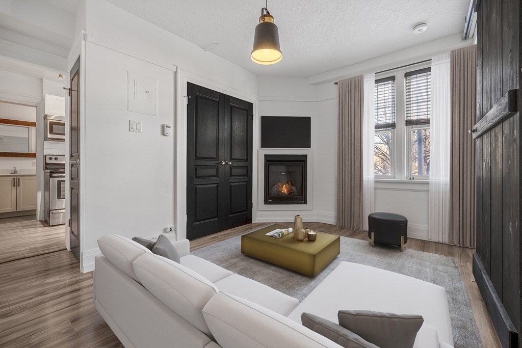 A modern living room with a fireplace and a white couch.