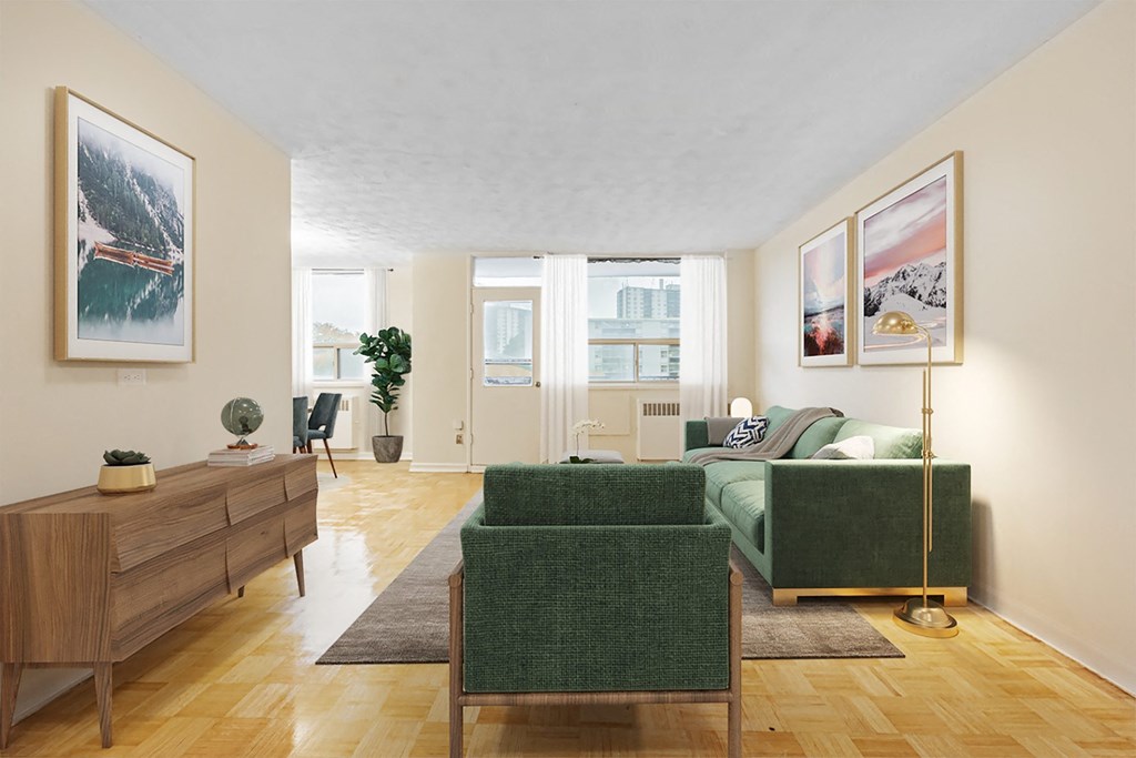 A living room with a green couch and a wooden dresser.