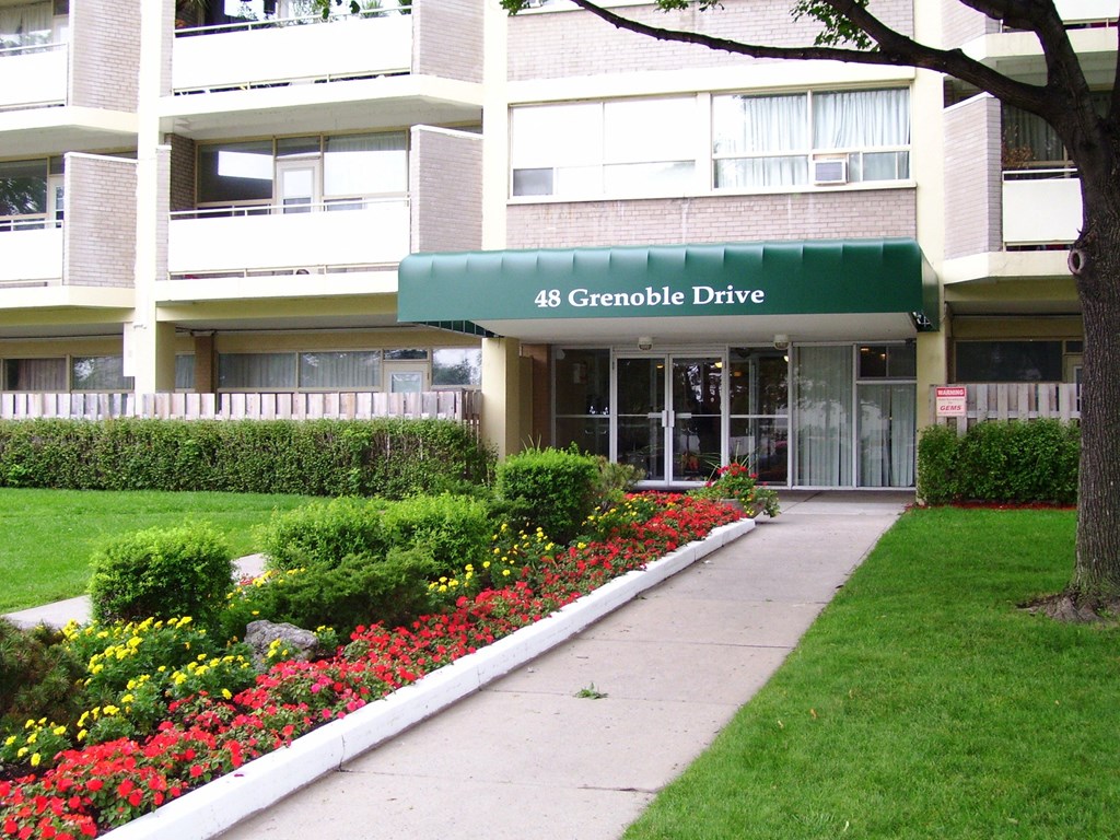 The building at 48 Grenoble Drive is a white apartment complex with a green awning.