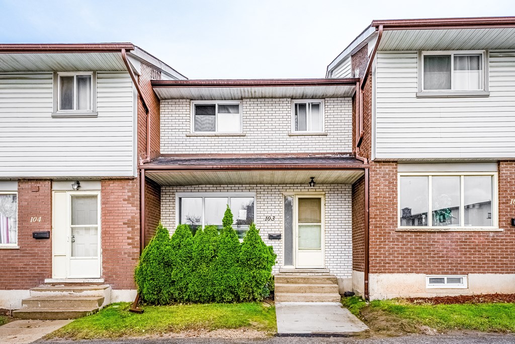 A house with a white door and a small front yard.