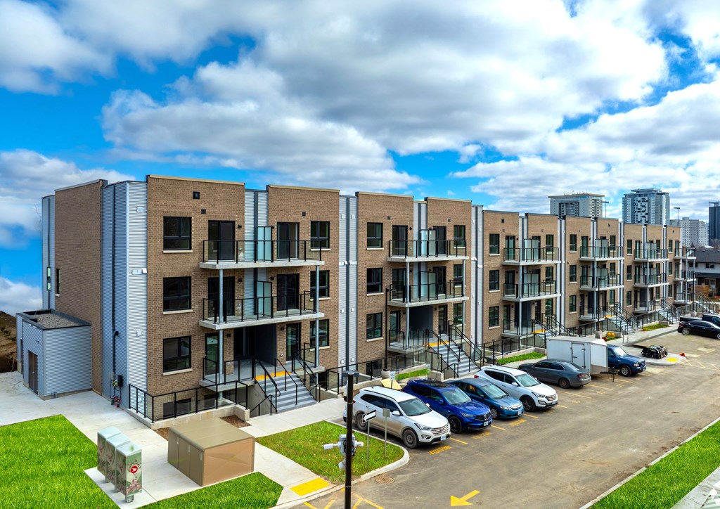 A large apartment complex with a parking lot in front.