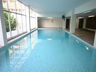 A large indoor swimming pool with a blue tiled floor.