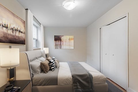 A bedroom with a bed, nightstand, and two pictures on the wall.