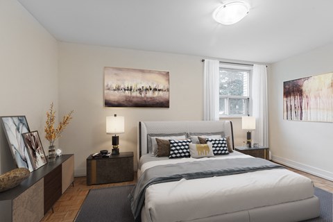 A bedroom with a large bed and a painting on the wall.