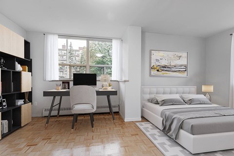 A bedroom with a large bed, a desk with a chair, and a bookshelf.