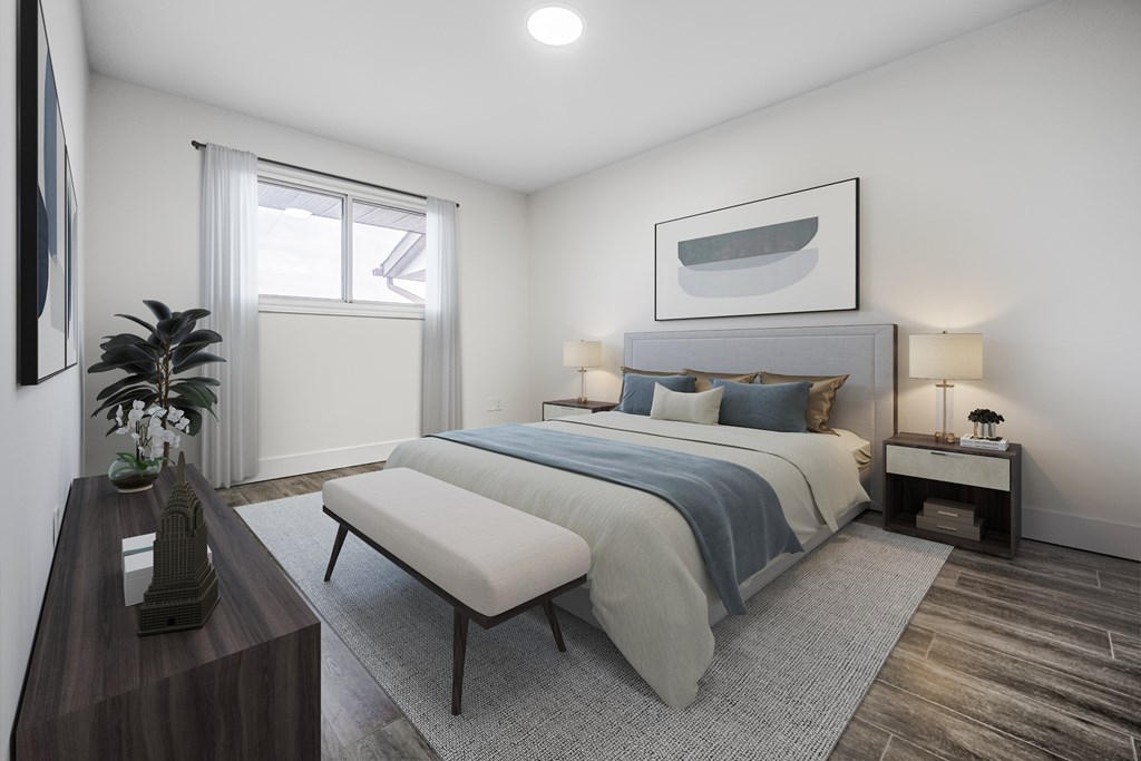 A bedroom with a large bed and a bench in front of it.