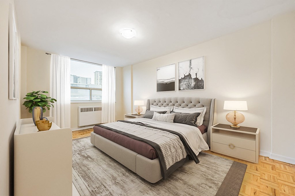 A bedroom with a large bed, a nightstand, and a plant on a pedestal.