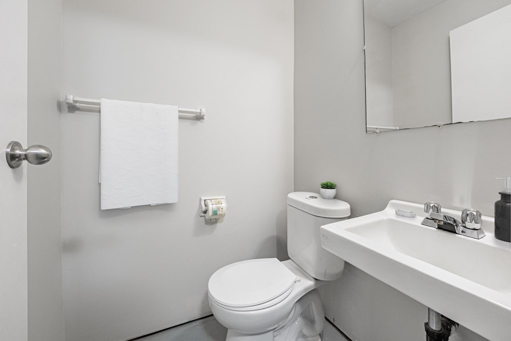A white toilet is next to a white sink in a bathroom.