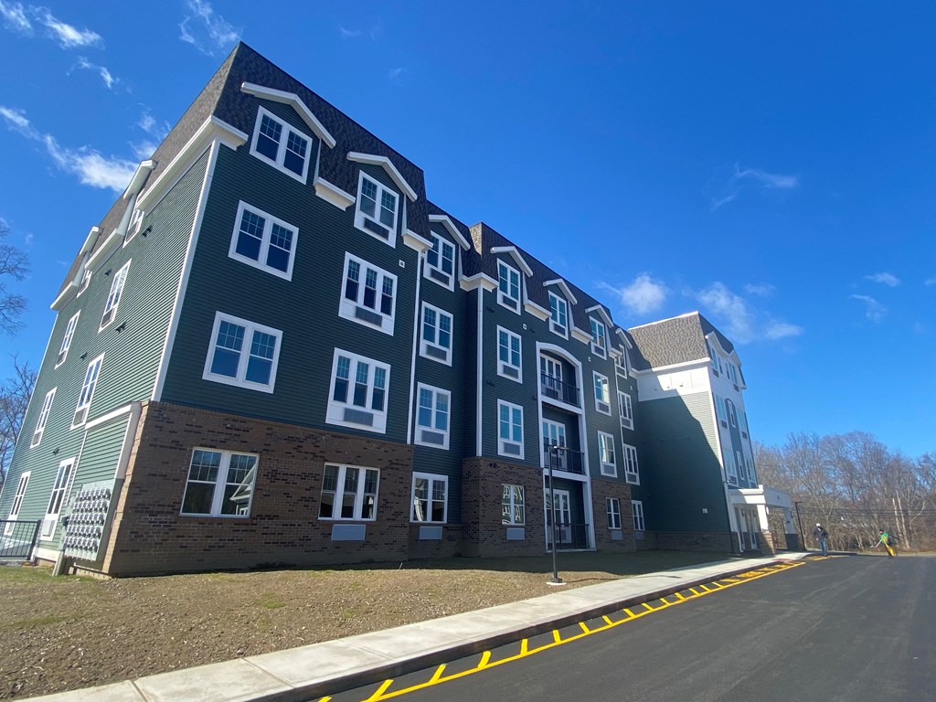 A large apartment building with a parking lot in front.