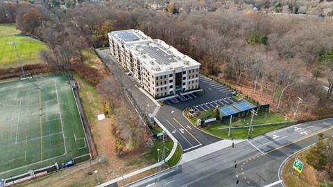 A large building with a tennis court in front of it.