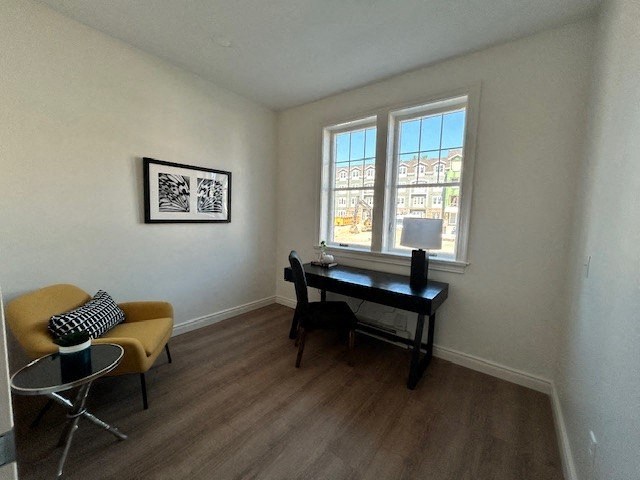 a living room with a desk and a window