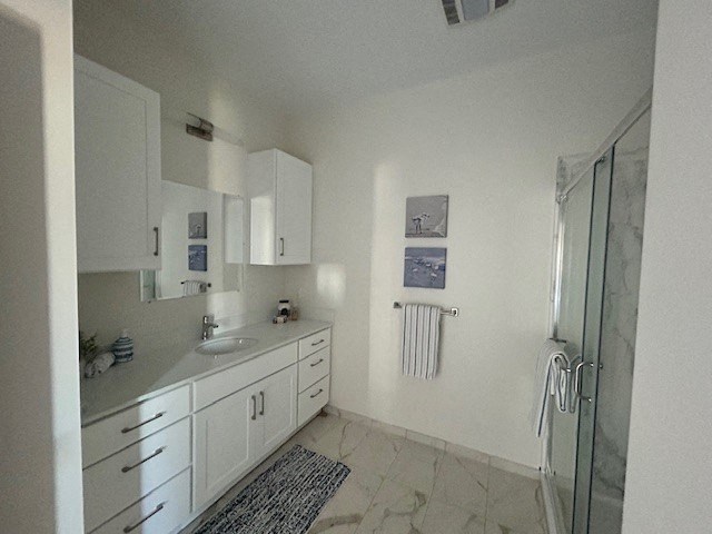 a white bathroom with a sink and a shower