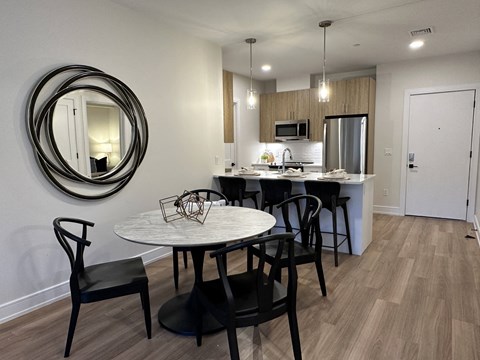 a kitchen and dining room area with a table and chairs and a sink and refrigerator
