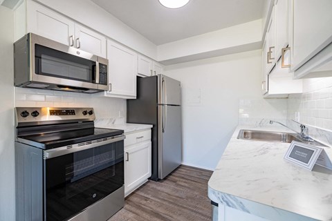 A kitchen with a black oven and a black fridge.