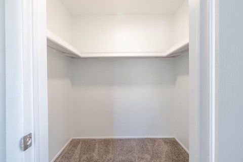 A small, empty room with a carpeted floor and white walls.