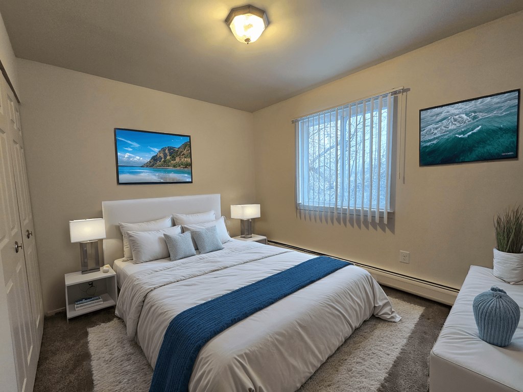 A bedroom with a large bed and a painting on the wall.