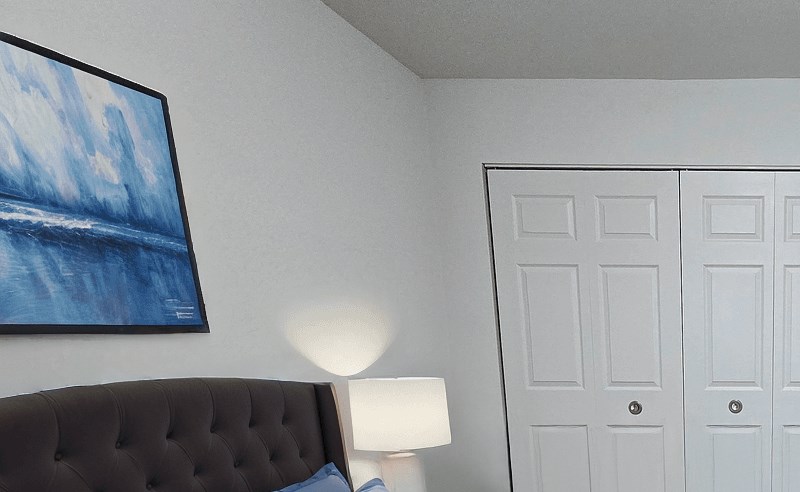 A bedroom with a bed, nightstand, and a television.