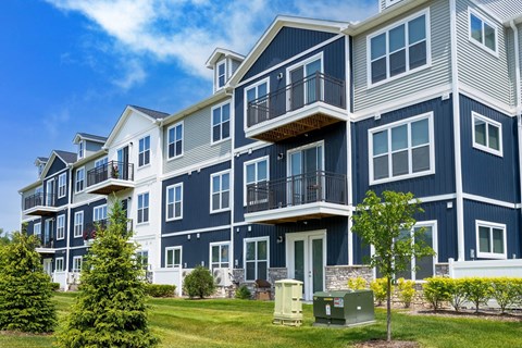a row of blue apartment buildings with balconies and trees