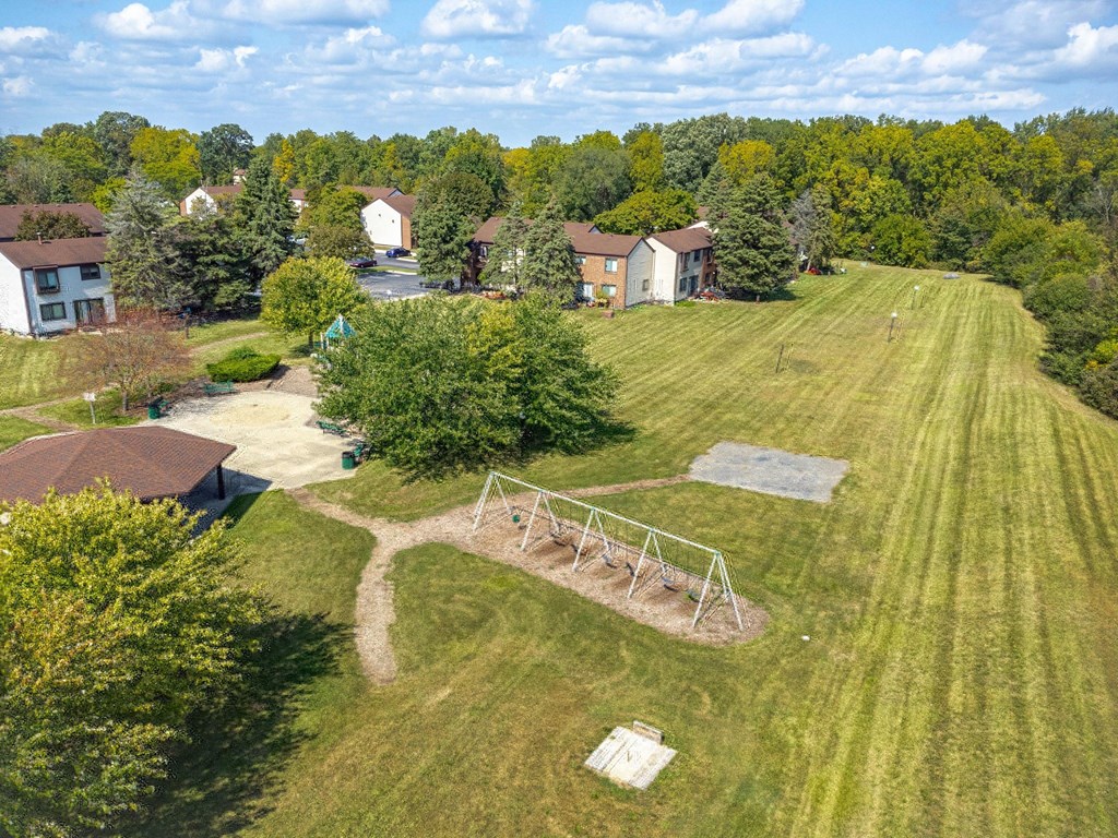 A park with a swing set and a soccer goal.