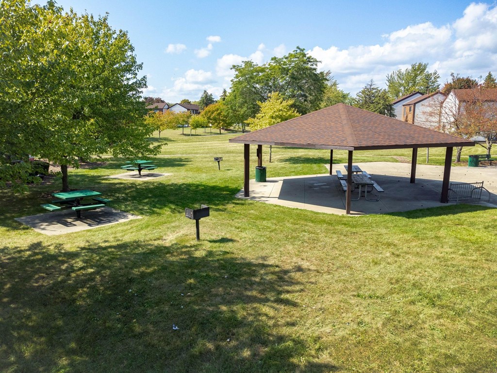 A park with a gazebo and picnic tables.
