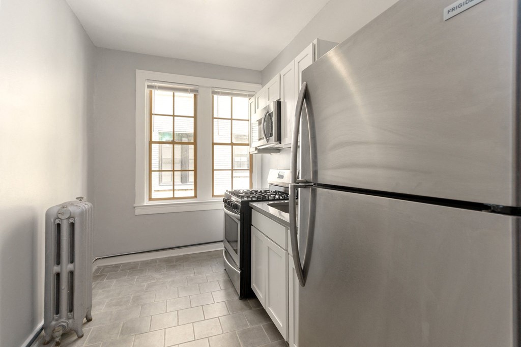 an empty kitchen with a stainless steel refrigerator and stove