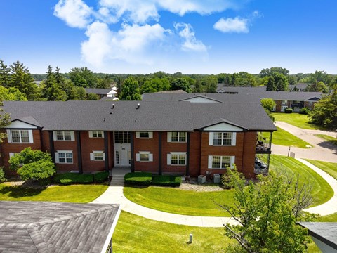 an aerial view of a brick house with a yard and trees