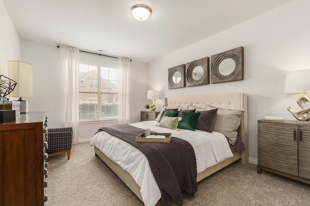 a bedroom with a bed and two mirrors on the wall