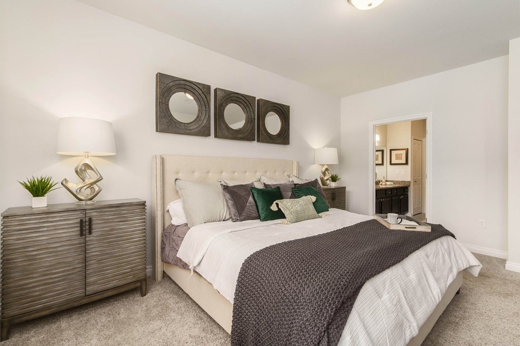 a bedroom with a bed and three mirrors on the wall