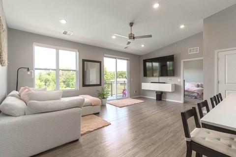 A spacious living room with a white couch and a television.