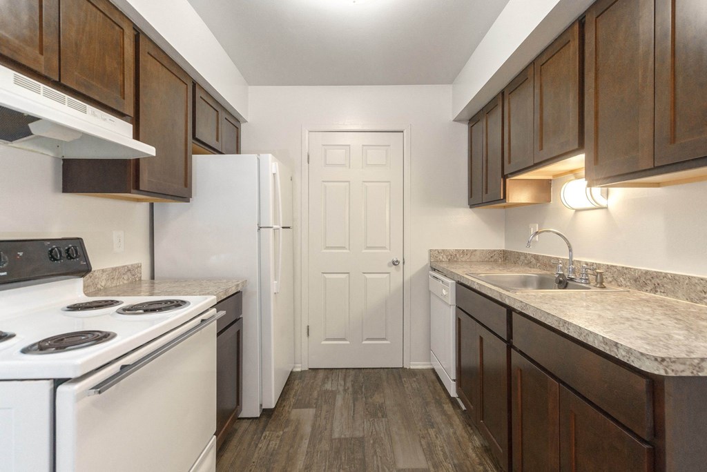 a kitchen with white appliances and brown cabinets