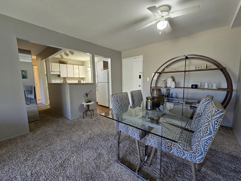 A living room with a glass table and chairs.
