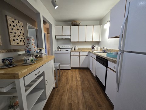 a kitchen with white cabinets and white appliances