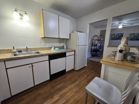 a kitchen with white cabinets and a sink and a refrigerator
