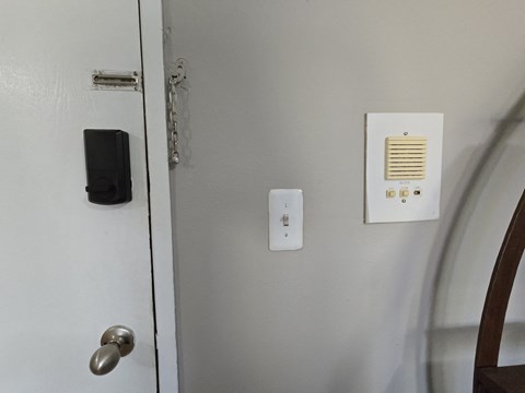 the door of a bathroom with a remote control on the wall