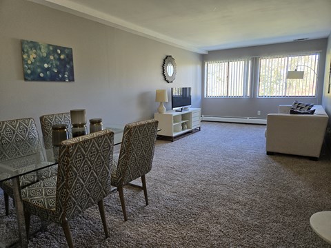 A living room with a glass table and chairs.