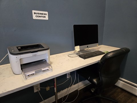 an office desk with a computer and a printer on it