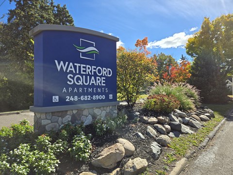 A sign for Waterford Square Apartments with a phone number on it.