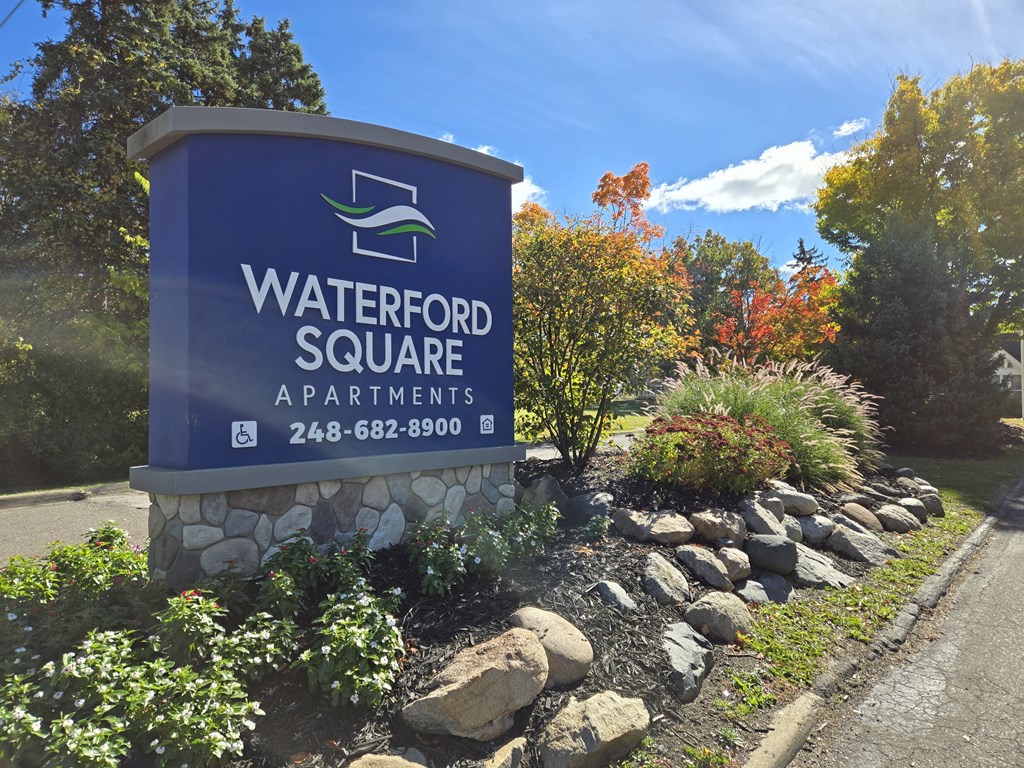 a sign for waterford square apartments on the side of a road