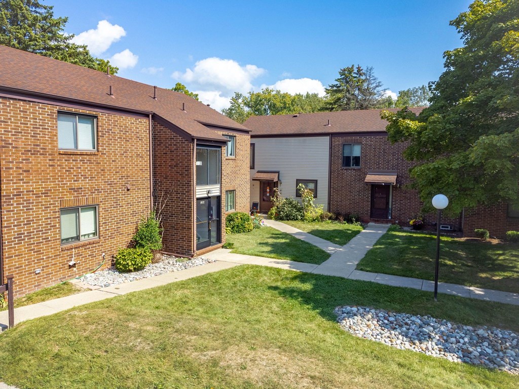 A sunny day at a residential area with houses and green lawns.