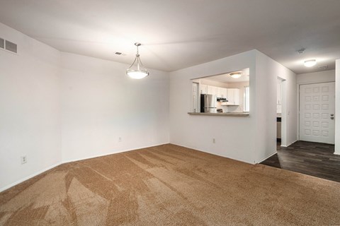 the living room and dining room in a new home with white walls and carpet