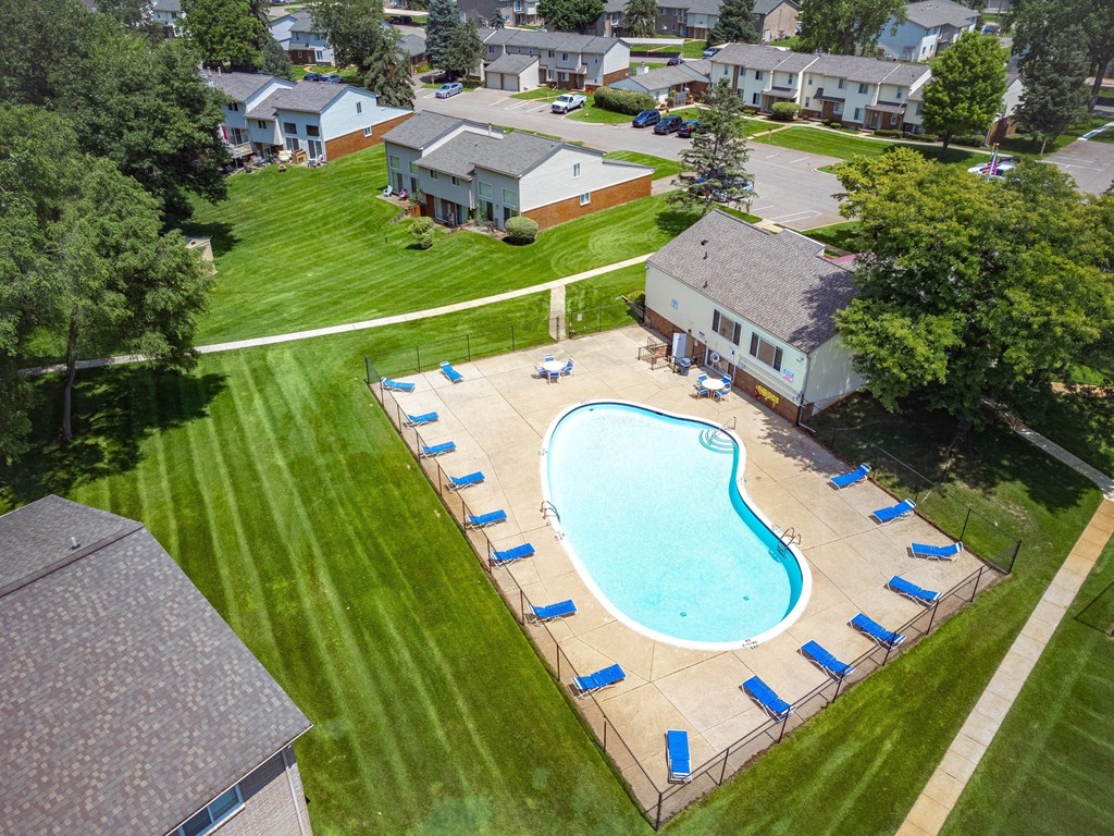 an aerial view of a swimming pool in the backyard of a house