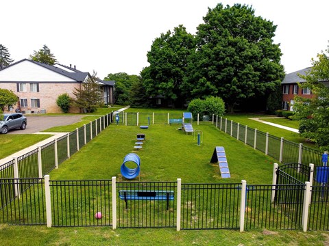 a fenced in play area with playground equipment in a yard