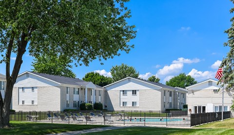 A row of houses with a pool in front.