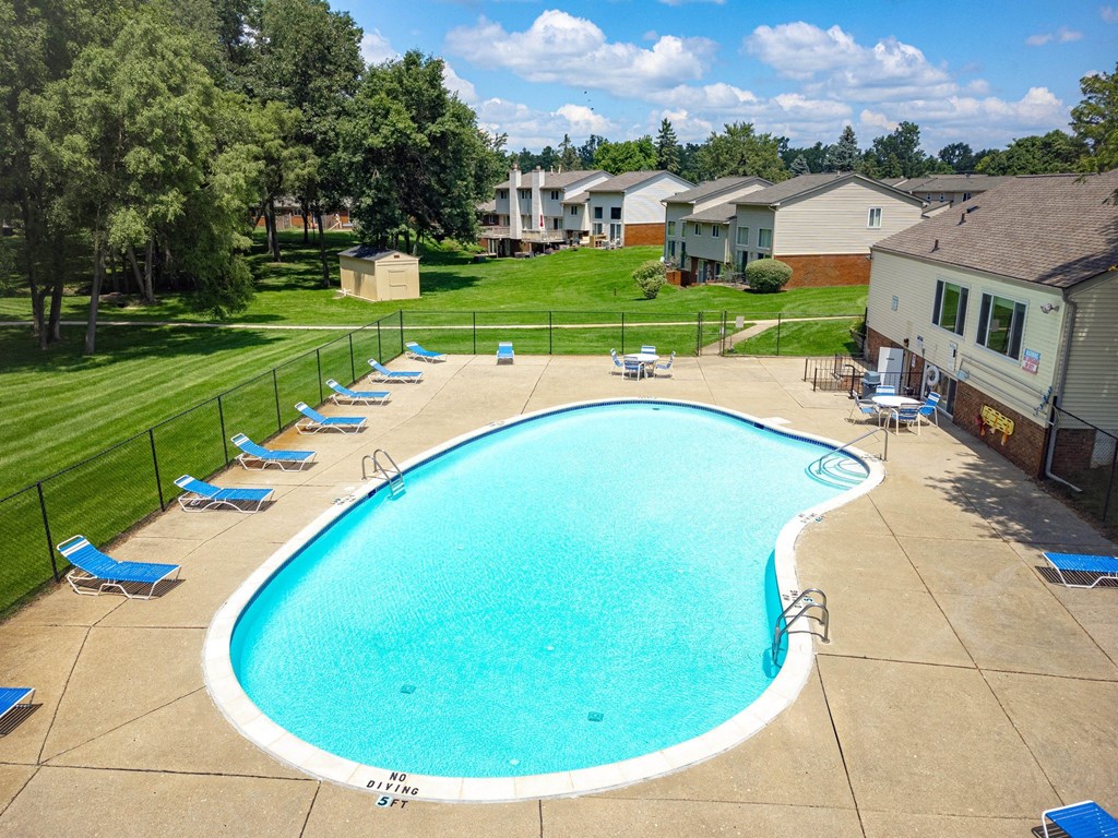 an aerial view of a swimming pool with chairs around it