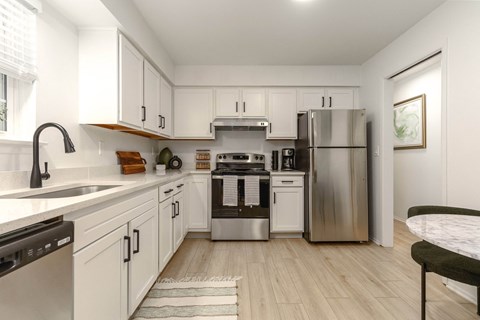 a kitchen with white cabinetry and stainless steel appliances