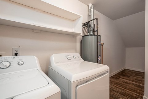 an empty laundry room with two washes and a dryer